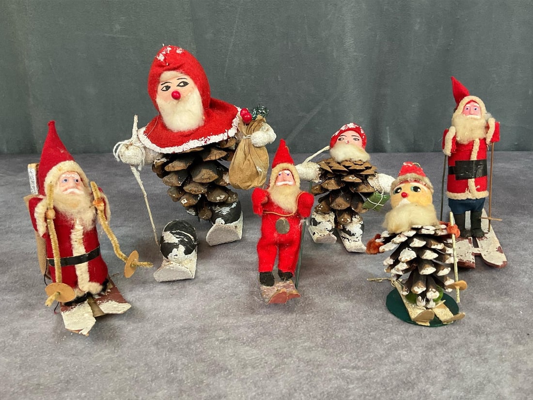 Skiing Santas: Three older 1940s painted face Santas, one marked Occupied Japan, small one is missing a ski pole. Three pinecone Santas, one missing a ski pole and larger one has a broken foot. Largest one is 5.5 in