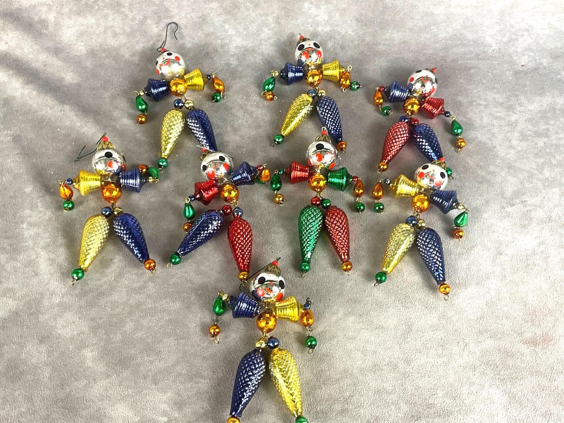 Christopher Radko Wiggle Man Ornaments II: Group of eight. Made in the Czech Republic. Some paint loss on the legs of all ornaments. Overall good condition. Each ornament measures 6 inches wide x 5 inches tall.