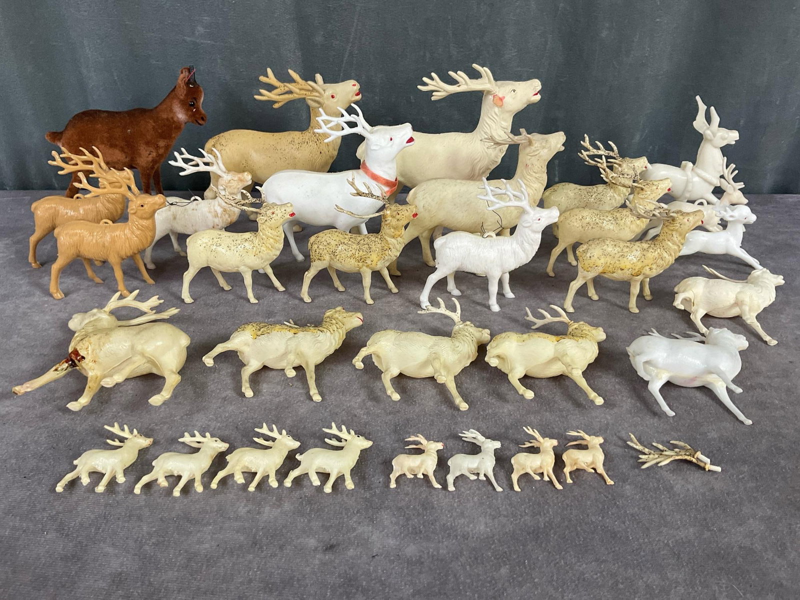 Celluloid & Plastic Reindeer: 31 in total, various sizes. Brown felt has broken antlers, marked Wagner Germany, 5 inches wide x 4.75 inches tall. Some marked USA, Japan, Occupied Japan. Five missing antlers, one broken leg. Fair t