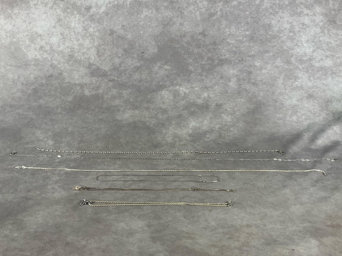 Sterling Necklaces: Six, chain style and length vary, all marked .925 or sterling. 1.47 ozt. Good condition. One necklace has a flip flop and another has a fairy charm.