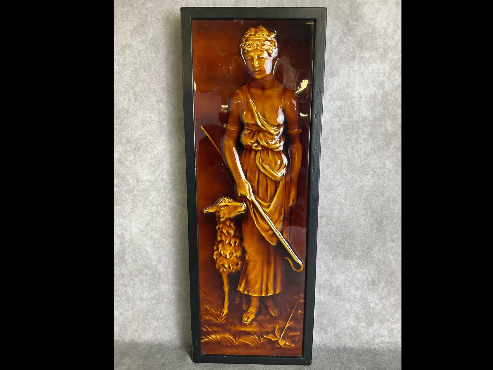 19th Century Trent Majolica Glazed Tile: Shepherdess with crook and sheep. Single tile in a contemporary frame. Online research indicates this was likely made by a New Jersey pottery but has not been examined out of frame. Chips to nose of g