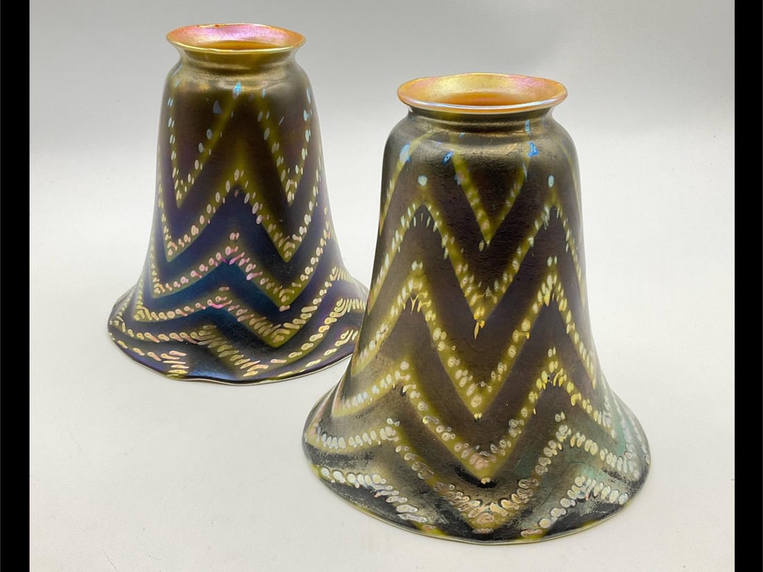 Pair of Art Glass Chevron Aurene Shades: Early 20th century. Gold aurene interior. Exterior pattern of pulled chevron in green to black and iridescent spots. Unsigned. One has a damaged interior, it has the appearance that the gold finish me