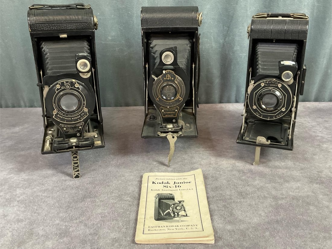 1920s Eastman Kodak Folding Cameras: No. 1A Pocket Kodak, No. 2A Folding Autographic Brownie, and no. 1 Kodex Junior six 16 with booklet. All open and close freely, bellows are in good condition, clean inside. Kodak Jr Six has a broken s