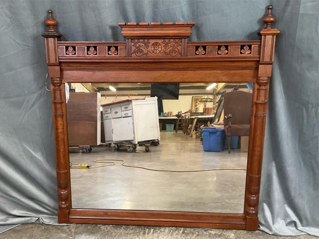 Victorian Eastlake Mantle Mirror: Late 1800s hand carved over mantle mirror. Carved leaf design with center floral medallion. Two top finials can be removed. Mirror backing is tongue and groove slats. Minor scratches on bottom front a