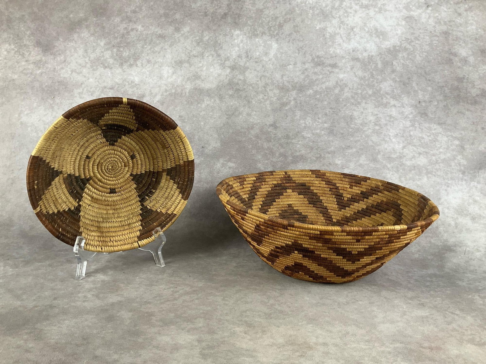 Decorative Woven Baskets: Hand woven baskets, group of two.Believed to be Native American. Both are in good condition. Smaller basket is 8.5 inches in diameter, larger basket is 12 inches in diameter.
