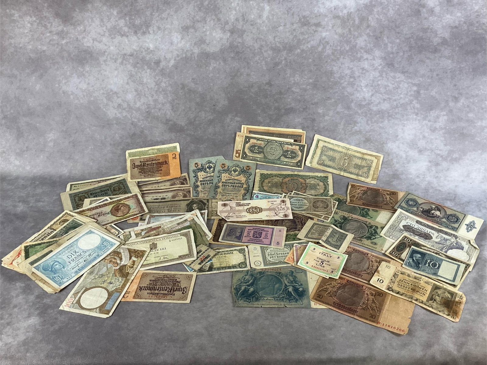 Foreign Paper Money: Large lot, approximately 80 pieces. Paper money from Italy, Russia, Mexico, France, Germany, Japan, and more. Various currency denominations. In fair to good condition.