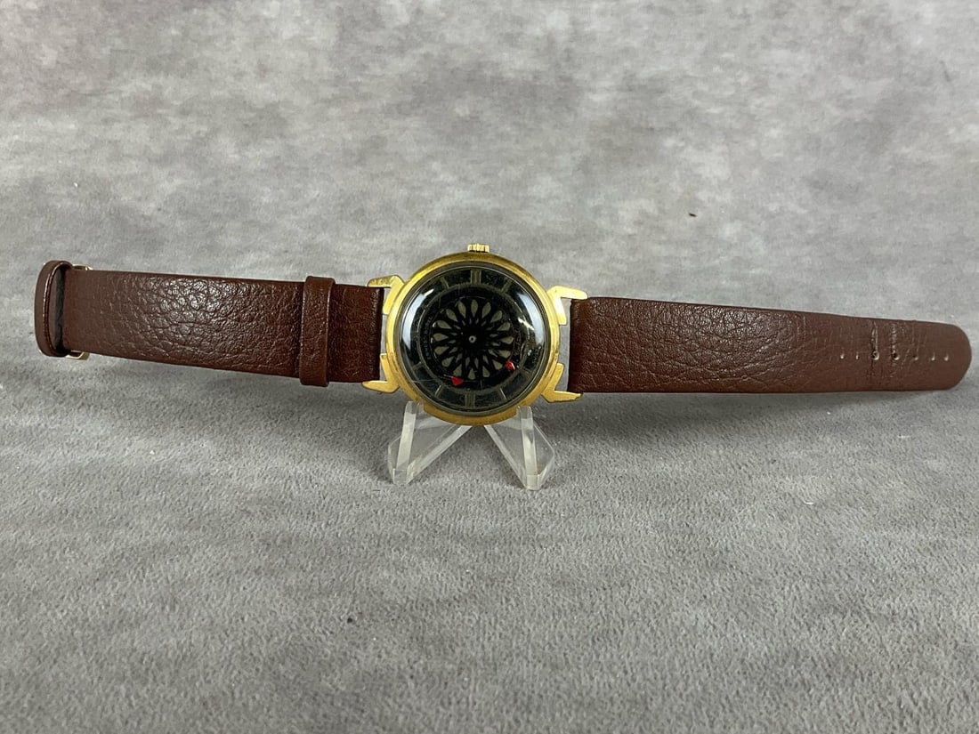 Earnest Borel Cocktail Watch: Seventeen jewels, kaleidoscope design, 14k electroplated with red hour and minute hands. Band is Spidel German leather. Non working order, but in fair to good condition. Measures 1 inch wide x 1 inch 