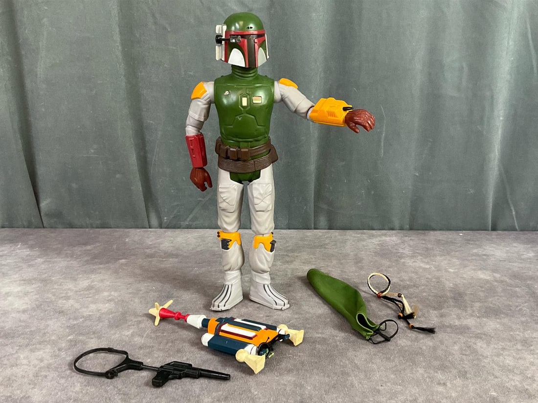 Star Wars Boba Fett Action Figure: 1979, made by Kenner. Complete with original cape, scalp ropes, gun and jet pack backpack. Backpack has some wear and there is paint loss throughout. Measures 5 inches wide x 12 inches tall.