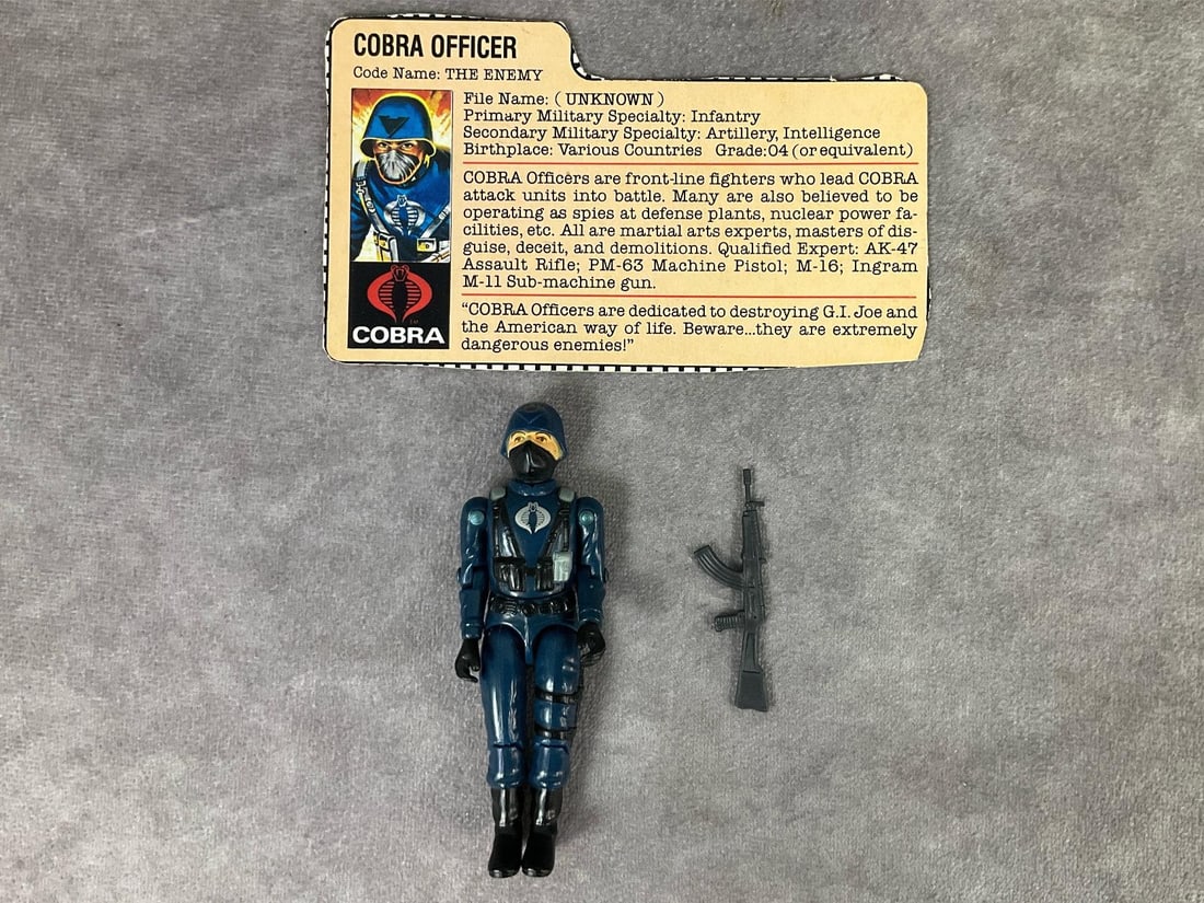 1982 Cobra Officer: G.I. Joe code name The Enemy. Straight arm version. Complete with original gun and file card. All joints are tight. Scratches to handle of gun. Figure in good condition, measures 3.75 inches tall.