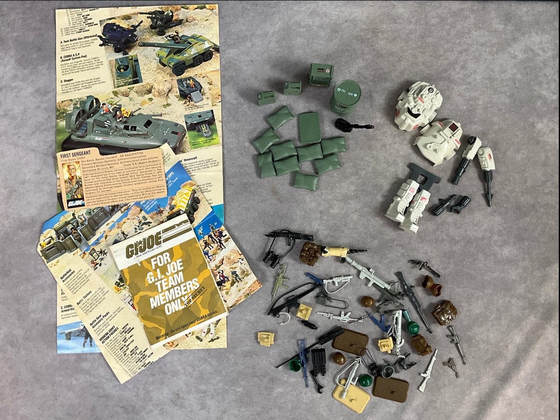 G.I. Joe Assorted Accessories & Advertisements: All made by Hasbro. 1983 Snake Battle Armor, 1984 Mortar Defense Unit set, missing one sandbag, and one battle stand. Assorted helmets, firearms, and accessories. First Sergeant Duke file card, and th