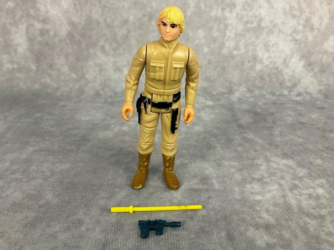 1980 Luke Skywalker: Made by LFL in Hong Kong, marked on back of legs. Complete with gun and yellow light saber. Wear to paint on belt, and yellow hair. Figure measures 3.75 inches tall.