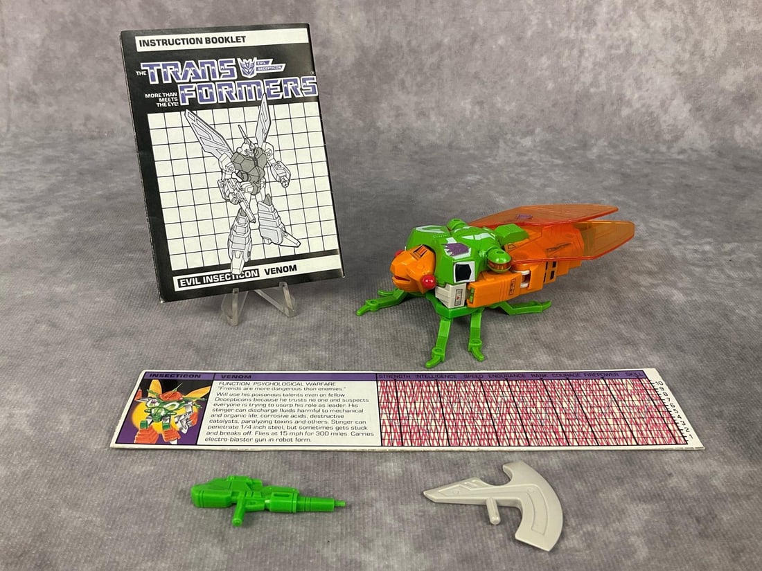 1985 Venom Transformer: Made by Hasbro in Japan. Complete with instruction booklet, tech spec card, and weapons. Missing decoder. Good condition but does have minor wear to decals. Transformer measures 5.25 inches long x 3.2