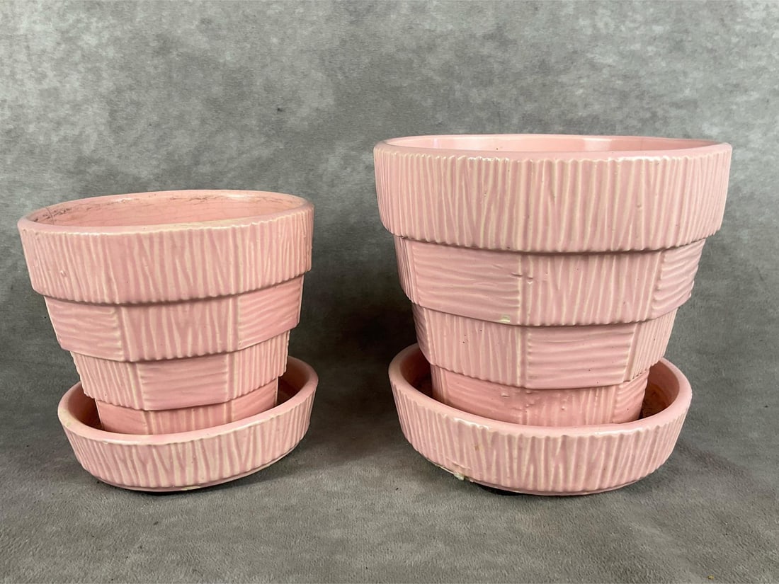 Mid-Century McCoy Basketweave Planters: 1953, set of two pink pots and saucers. Marked on bottom. Sizes are 4 and 5 inches in diameter. Both pieces have crazing, cracks, and chips to saucers. The largest planter is 5 inches tall x x 6 inche