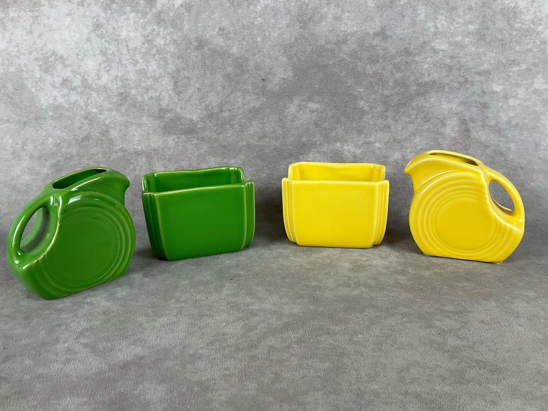 Fiestaware Pitchers & Packet Holders: Two sets. One meadow green mini disc pitcher and sugar packet holder, one sunflower yellow mini disc pitcher and sugar packet holder. Both in good condition, green pitcher has a black scuff. Pitchers