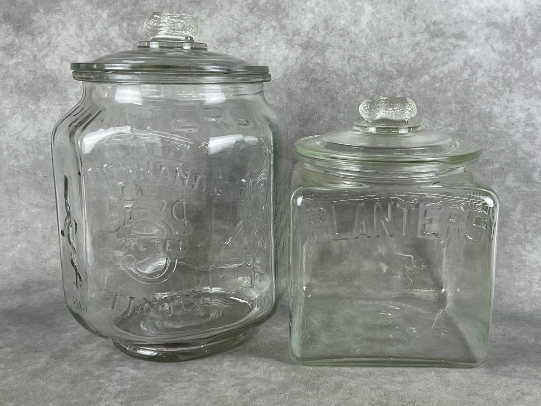Vintage Planters Advertisement Glass Peanut Containers: Group of two. One is octagon, one is square. Made for Planters Peanuts advertising. Good condition. Larger jar measures 9 inches wide x 13 inches tall including lid.