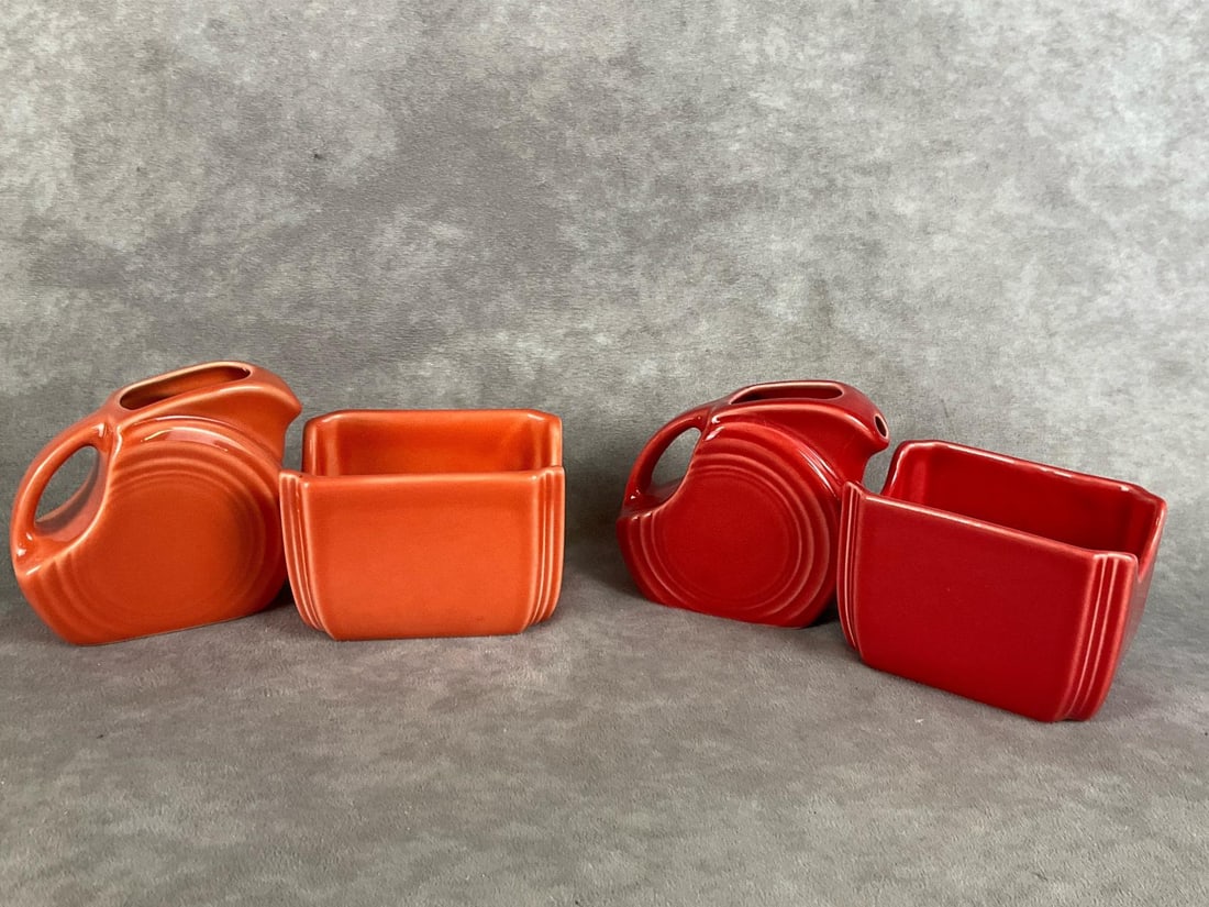 Fiestaware Pitchers & Packet Holders: Two sets. One Persimmon colored mini disc pitcher and sugar packet holder, one Scarlet mini disc pitcher and sugar packet holder. Both in good condition. Pitchers measure 3 inches wide x 4 inches tall