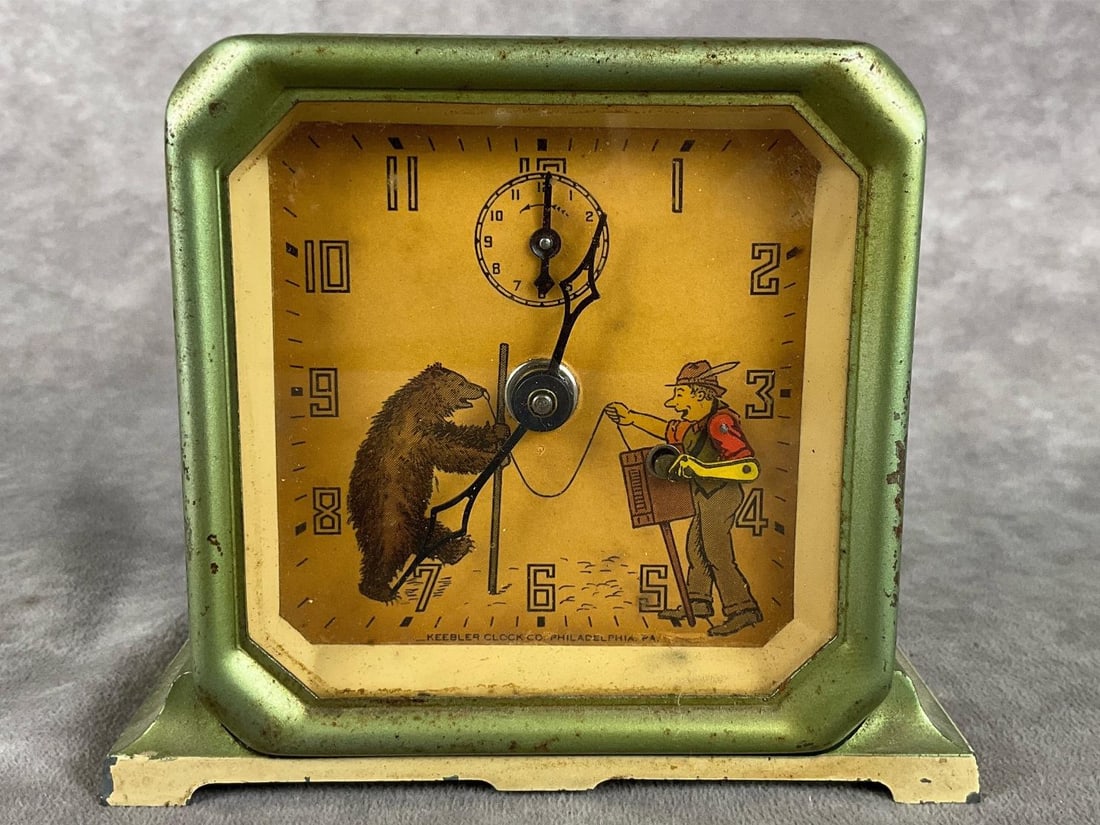 Keebler Organ Grinder Animated Alarm Clock: Made in the 1930s by Lux Clock Manufacturing. Paper clock face shows an image of an organ grinder and a bear. His arm moves with each second. Clock works and alarm sounds. Some rust to tin capsule and