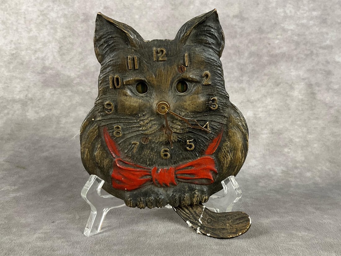 Lux Tin Cat Clock: Animated black cat clock made of tin, eyes move with the tail. In non-working condition. Paint loss on ears and tail. Measures 4.5 inches wide x 5.5 inches tall without the tail.
