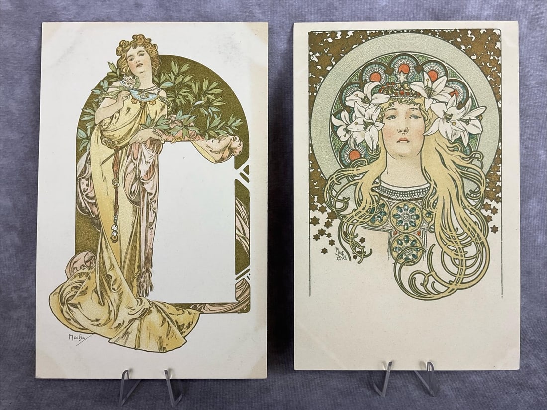 Alphonse Mucha Postcards: Two unused Art Nouveau postcards signed Mucha on front with undivided backs. Good condition but does have discoloration on front and back from being in an album. Hard plastic sleeves for both. Measure