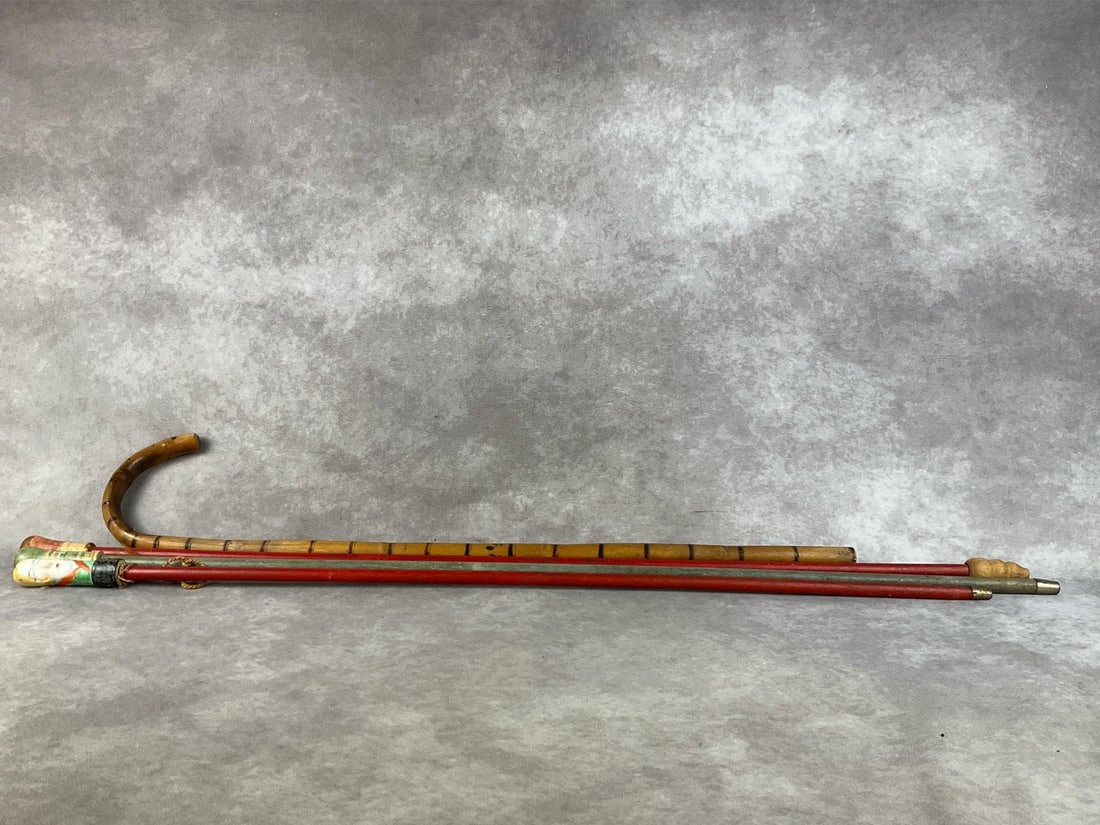Japanese Canes: Three early Japanese canes, two with wooden handles, and one with a hand painted porcelain handle. One curved bamboo walking cane. All are in fair to good condition. Longest measures 34.5 inches tall.