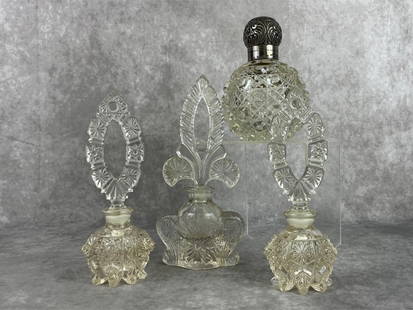 Art Deco Perfume Bottles: English cut glass scent bottle with sterling silver chased lid, three crystal cut glass perfume bottles. All in good condition with hinge broken on silver top. Tallest measures 3.25 wide x 7.75 tall.
