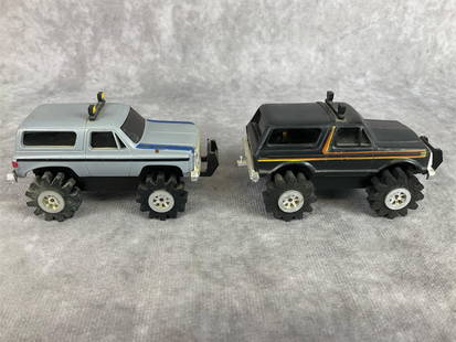 Schaper Stomper 4x4s: Two 1980s vehicles made by a Schaper Mfg. Black Ford Bronco and Gray Chevrolet Blazer, both light up but do not run. Shows signs of wear. Measures 3.5 inches long x 1.75 x 2 inches tall.