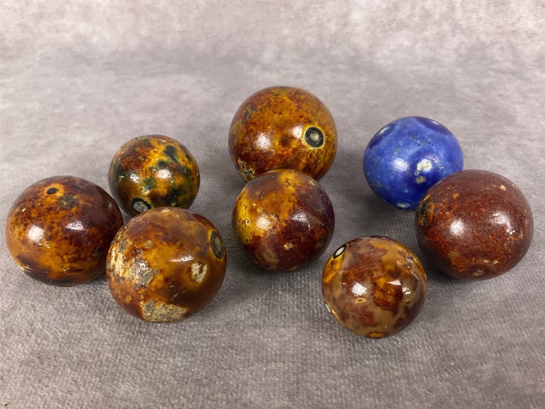Bennington Marbles: Eight turn of the century glazed clay marbles made by Bennington. One blue glaze and the rest brown. All have imperfections. Largest one measures approximately 1.5 inches.