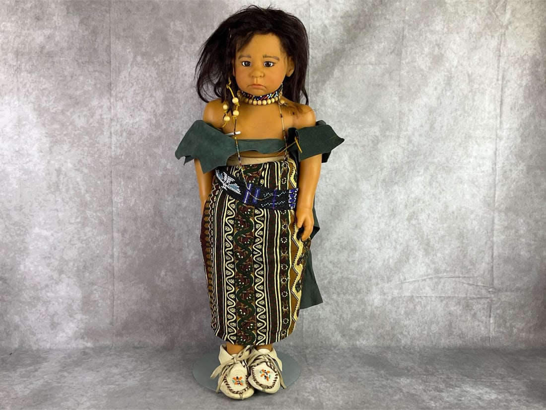 Gotz Native American Doll: 1992 Gotz doll number 226, marked on back of neck. Cloth body and joints, leather shirt, glass bead necklace and belt, and leather moccasins. Scuffs on face, and hair is falling out, a hole in dress. 
