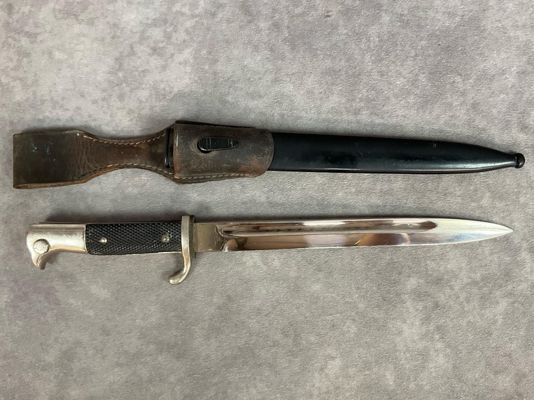 WWII German Police Bayonet: Heer Army long 98k dress bayonet with scabbard. WWII Era German police bayonet, unmarked, with original black metal scabbard and leather frog. Black bakelite grips, original red felt in rifle slot. We