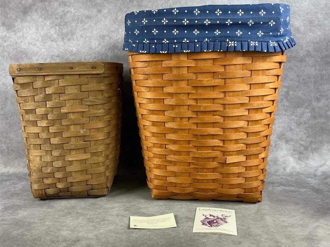 Longaberger Waste Baskets: One early Longaberger waste basket, and one 11703 medium wastebasket with COA, liner and plastic liner. Both in good condition. Largest measures 10 inches wide x 13 x 16 inches tall.