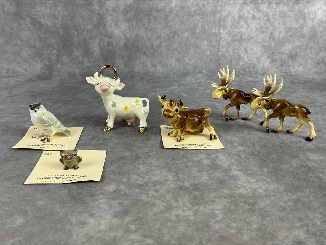 Hagen Renaker Mixed Lot: Lot of six Hagen Renaker moose, cows, and owls. All in good condition and some on original paper. Largest measures 2 inches wide x 2.5 inches tall.