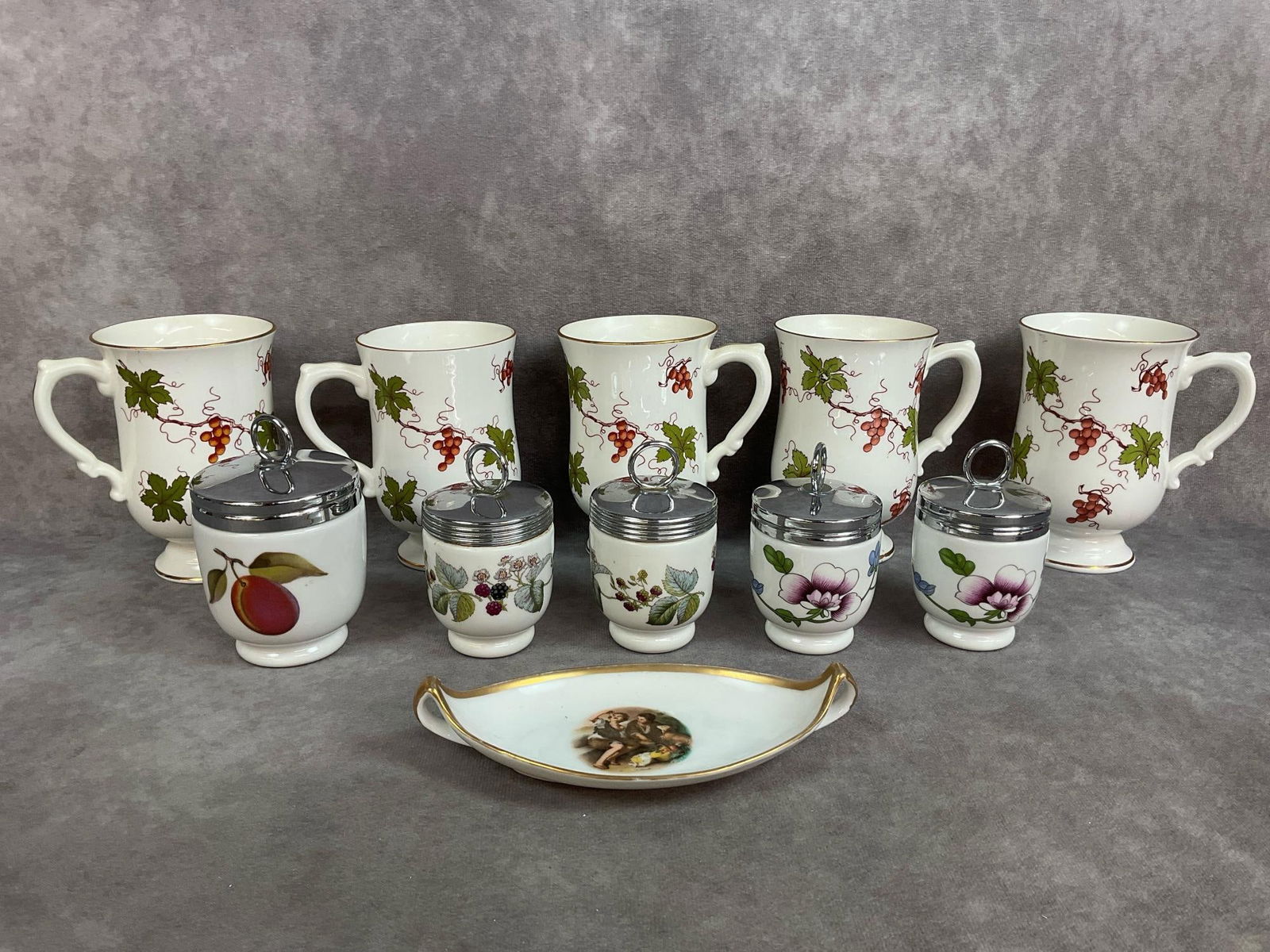 English Kitchenware: Five vintage fine bone china mugs made by Royal Victoria in England. Five Royal Worcester porcelain egg cups made in England. Antique German trinket dish with gold trim. Good condition. Mugs measure 2
