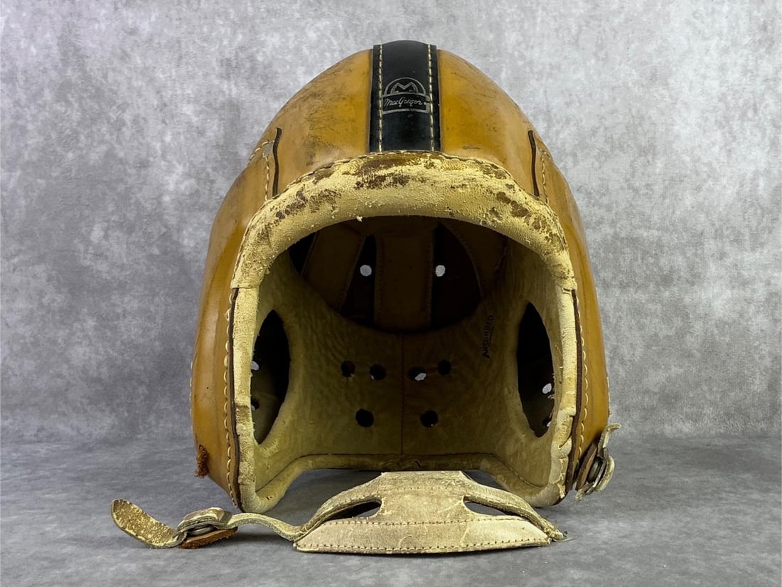 1940s MacGregor Football Helmet: 1940s MacGregor leather football helmet model H612 in gold with black stripes. Chin strap is unattached from the helmet, leather has some discoloration and splitting. Measures 8.25 inches wide x 10.5 