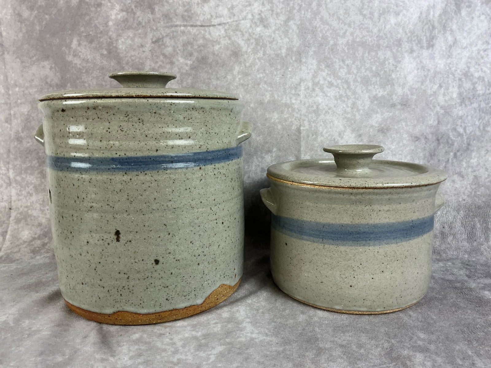 Modern Stoneware Canisters: Two stoneware pottery glazed canister. Grey and blue in color with speckles. In good condition. Largest cannister measures 7 inches in diameter x 7 inches tall.