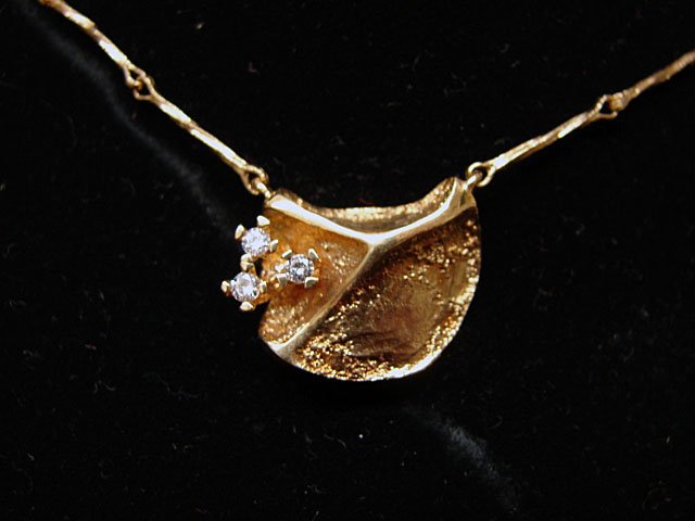Ole Lynggaard Jewelry: Ole Lynggaard leaf pendant with twisted link chain. 18k yellow gold, pendant has three accent diamonds (.12 cttw). Marked "OLEL 750 18k." Model # 726-4. 8.5 grams total weight. Comes with original Lyn