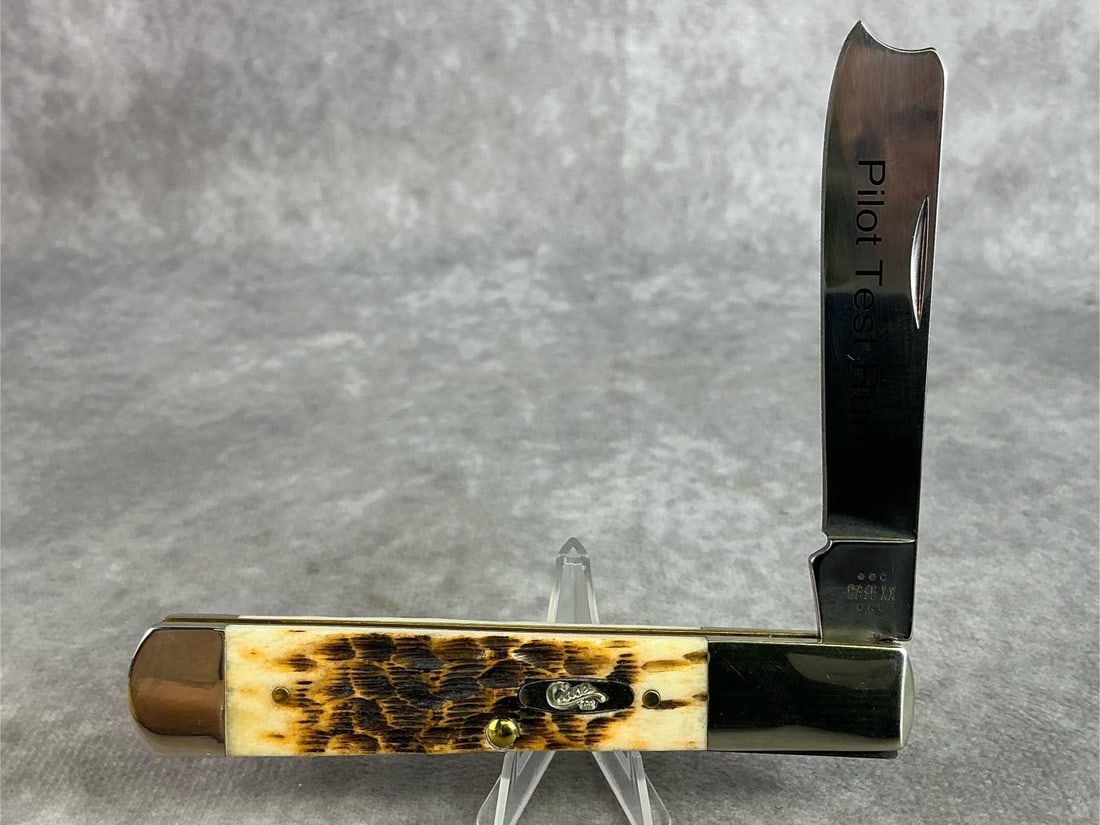 Case XX Amber Bone Pilot Test Run Razor: Item No. 91596. Amber Bone Peach Seed Jig One Blade Razor. Never sharpened, never carried, tight snap. Comes with box. In good condition. Measures 4 inches, closed. Pilot Test Run is printed on the bl