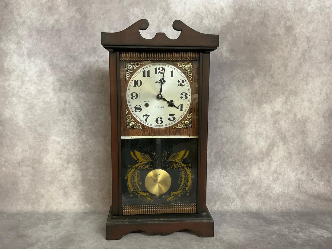 Alaron Table Clock: From the Starlite Drive In Theater in Christiansburg, VA. Mid 1900s 31 day Alaron clock with pendulum and key. Appears to work when wound. Measures 12 inches wide x 5.25 x 23.5 inches tall.