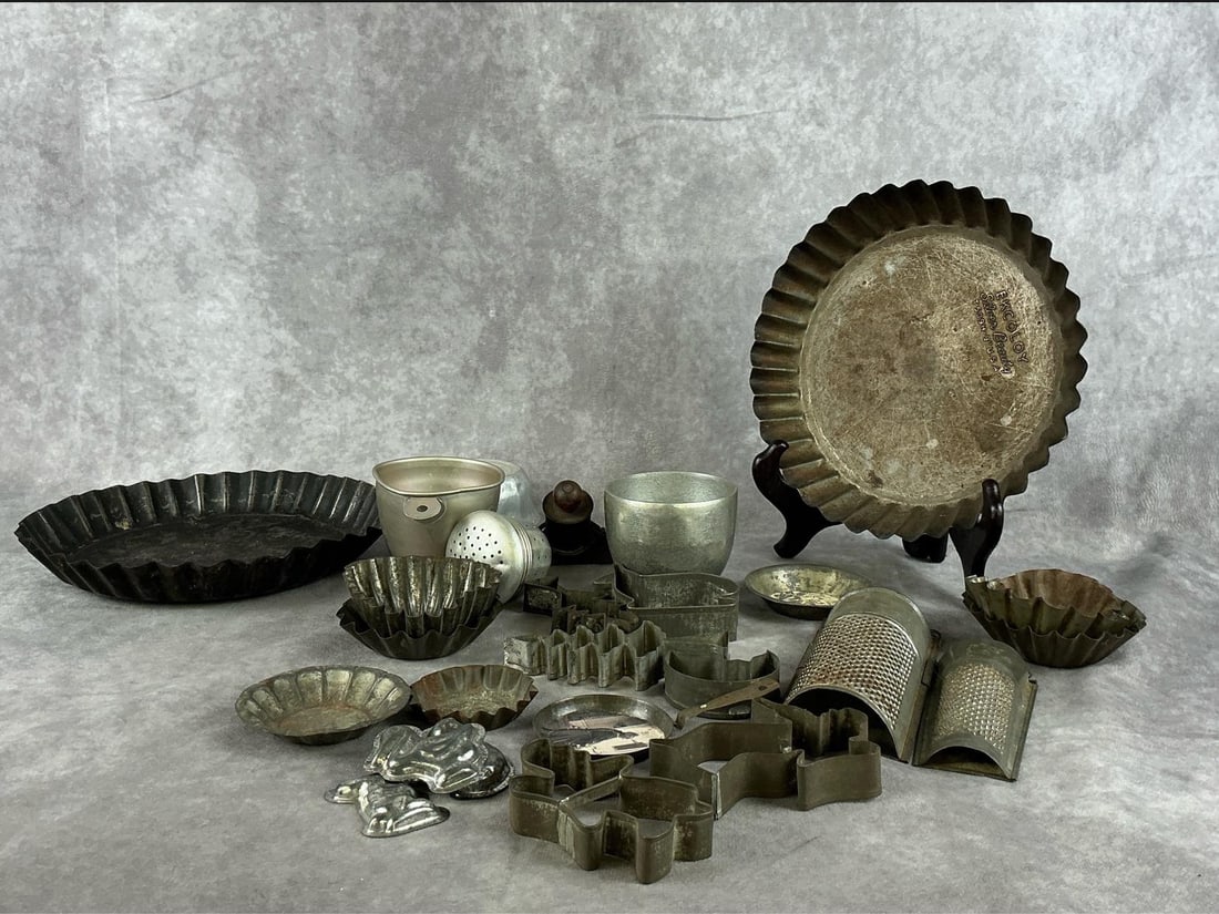 Primitive Tin Baking Finds: Early 1900s collection of tart pans, cookie cutters, measuring cups, graters and more. All in fair condition with rust present on most. Excoloy tart pan measures 9 inches in diameter x 2 inches tall.