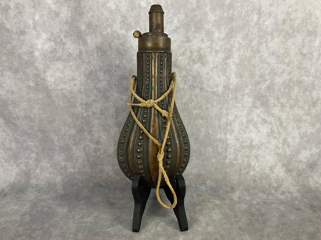 Black Powder Flask: 1860s to 1880s copper black powder flask with spout, possibly made by James Dixon and Sons. Body is a ribbed bubble gourd shape with loops on either side. Spring and mechanics still work. Patina to co