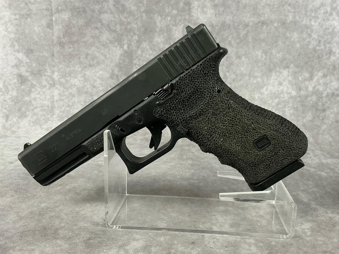 Glock Model 22 40mm Pistol: Serial No. CXU097US. Glock 22 chambered in a 40 cal. This is a third generation Glock with stippling. Pitting to slide. Bore is in good condition with no pitting, but visible signs of use. Grips are p