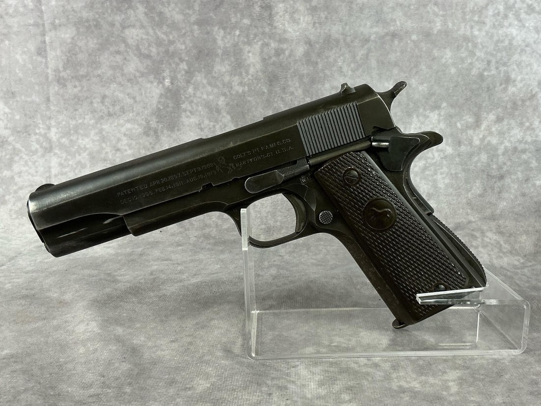 Colt 1911-A1 45 Army Pistol: Serial No. 811669. WWII era pistol manufactured in 1943. Original grips has patent dates on the side. United States Property Army with serial number printed on the other side. Finish is fair to good c