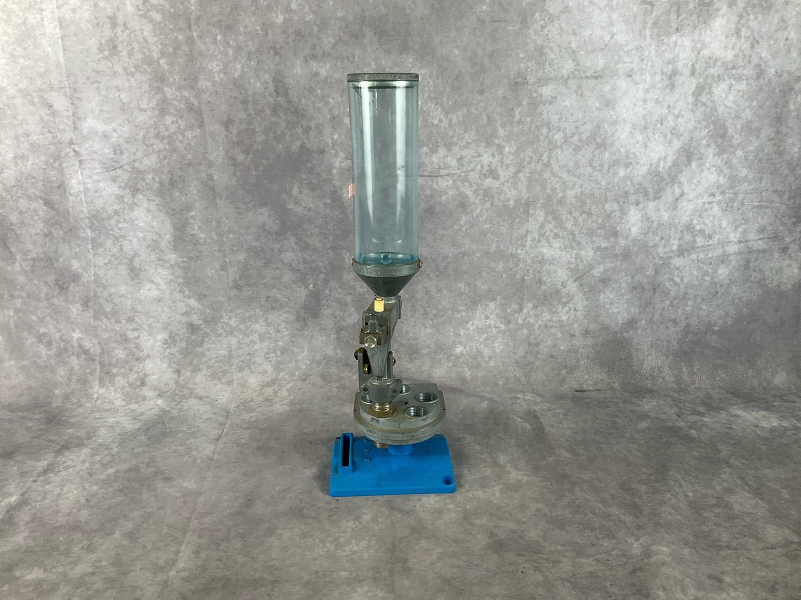 Dillon Reloading Toolhead with Stand: Dillon Reloading Toolhead with Stand. New never used. Measures 5 inches wide X 4.5 X 16 inches tall. Small crack in cylinder wall.