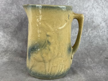 Early 1900s stoneware pitcher with embossed stag and trees. Heavy crazing and the blue painting