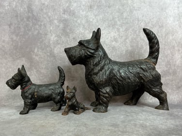 Three antique cast iron Scottish Terriers. Large door stop and two smaller figures. The two smaller
