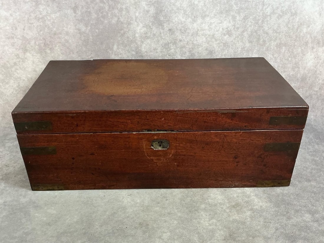 Circa 1830 Lap Top Desk. Mahogany with tulip poplar secondary wood. Brass corner bands. Dovetailed: Circa 1830 Lap Top Desk. Mahogany with tulip poplar secondary wood. Brass corner bands. Dovetailed side drawer with brass bail handle. Felt writing surface. Some loss to escutcheon. Two small cracks t