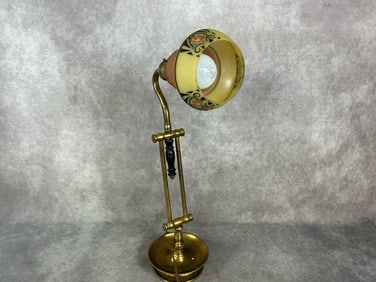 Early 1900s brass desk lamp with painted glass shade with stenciling on outer rim. Rust present.
