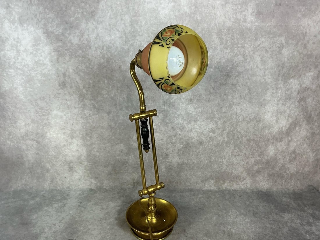 Early 1900s brass desk lamp with painted glass shade with stenciling on outer rim. Rust present.: Early 1900s brass desk lamp with painted glass shade with stenciling on outer rim. Rust present. Otherwise in good condition. Measures 5.5 inches in diameter x 21 inches tall.
