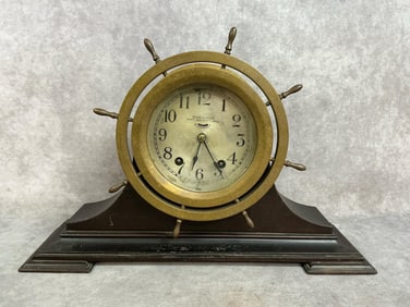 Early 1900s clock. Ship's bell clock in brass case on wood backboard. Eight day, seven jewel