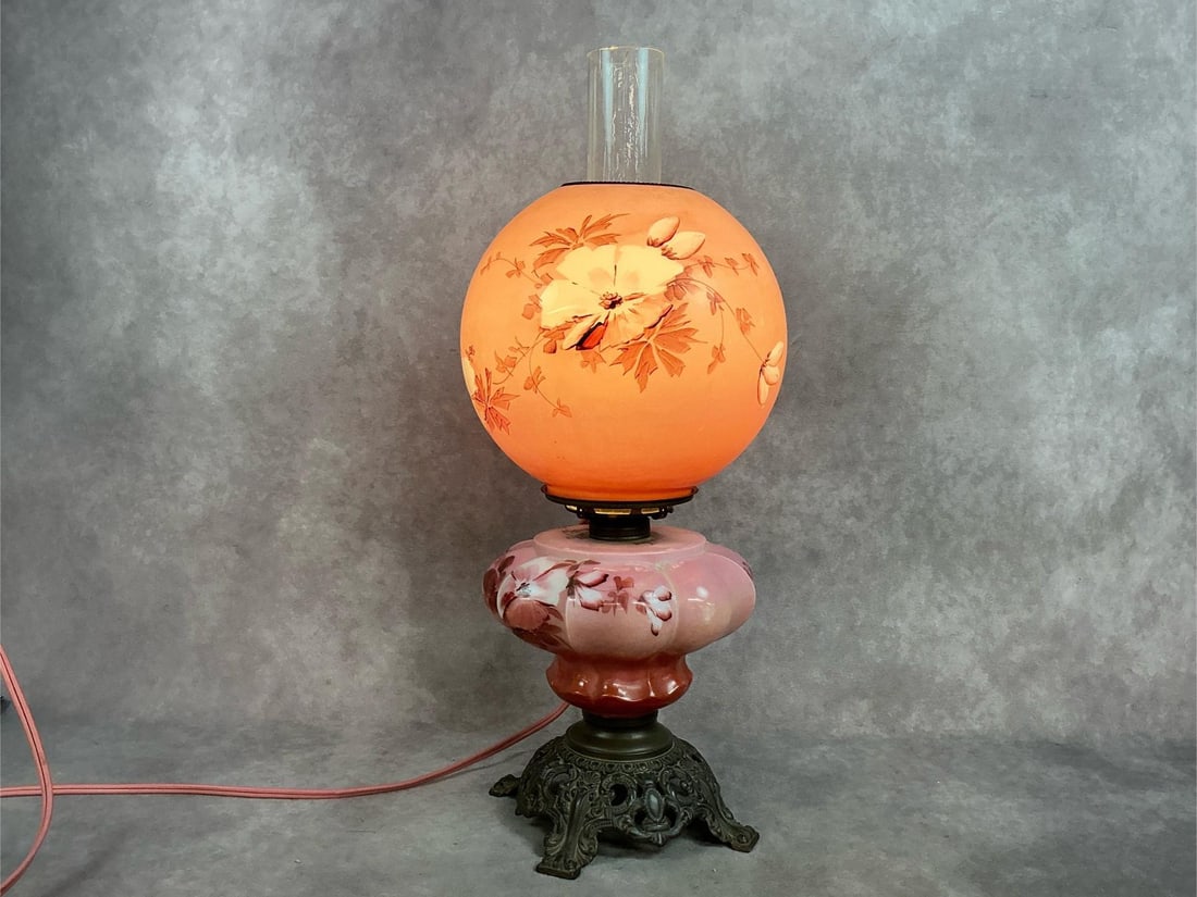 Early 1900s electric Gone with the Wind hurricane style lamp with floral design on pink glass base.: Early 1900s electric Gone with the Wind hurricane style lamp with floral design on pink glass base. In good condition. Measures 8 inches wide x 21 inches tall with globe.