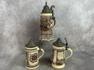 Three early 1900s steins. German made stoneware with pewter hinged lids. Intricate painted and